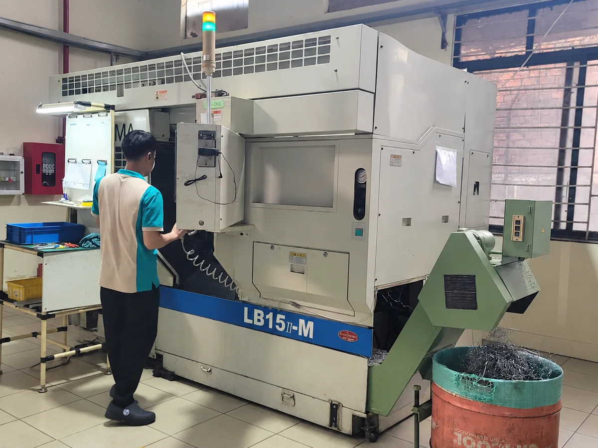 Operator at an Okuma LB15-M CNC mill-turn lathe in the turning cell at Far East High Tech