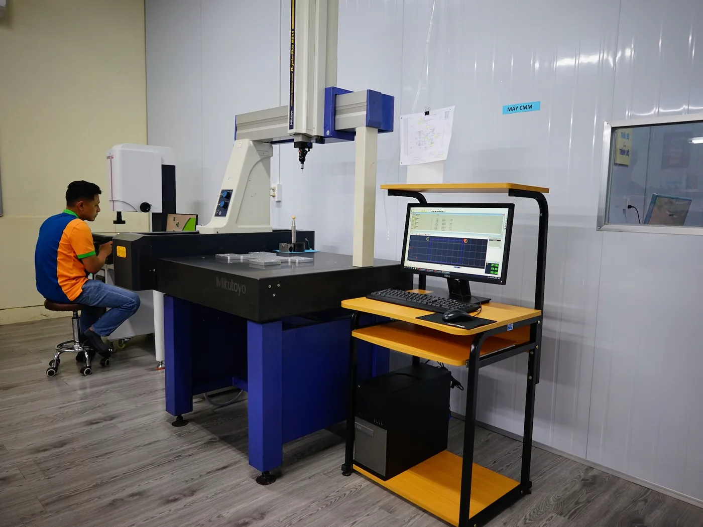 Quality control staff operating a coordinate measuring machine in the inspection room at Far East High Tech