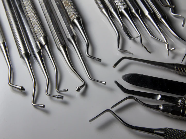 Stainless steel surgical and dental instruments laid out on a table