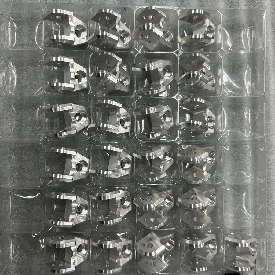 CNC milled brackets packed one per cell in a clear thermoformed tray